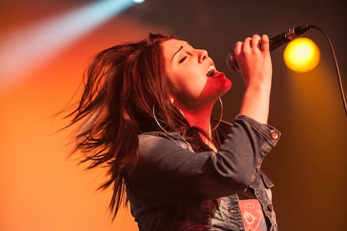 Young Woman singing at a student rock concert